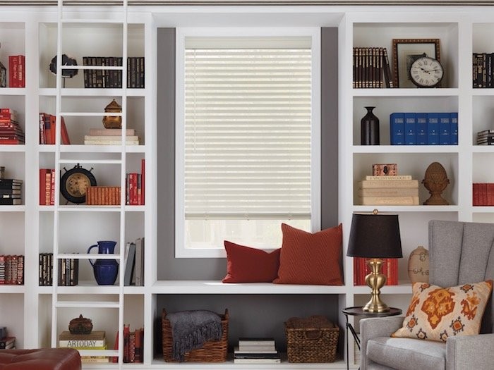 A home office with shelfs and books sorted by color